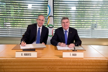 Brian Roberts of Comcast - the owner of NBCUniversal - and Dr Thomas Bach signing the deal